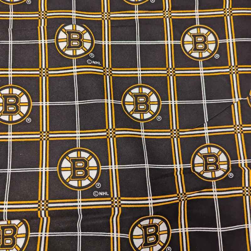 Boston Bruins plaid flannel cotton fabric with black, gold, and white tartan design and repeating NHL Bruins logos.