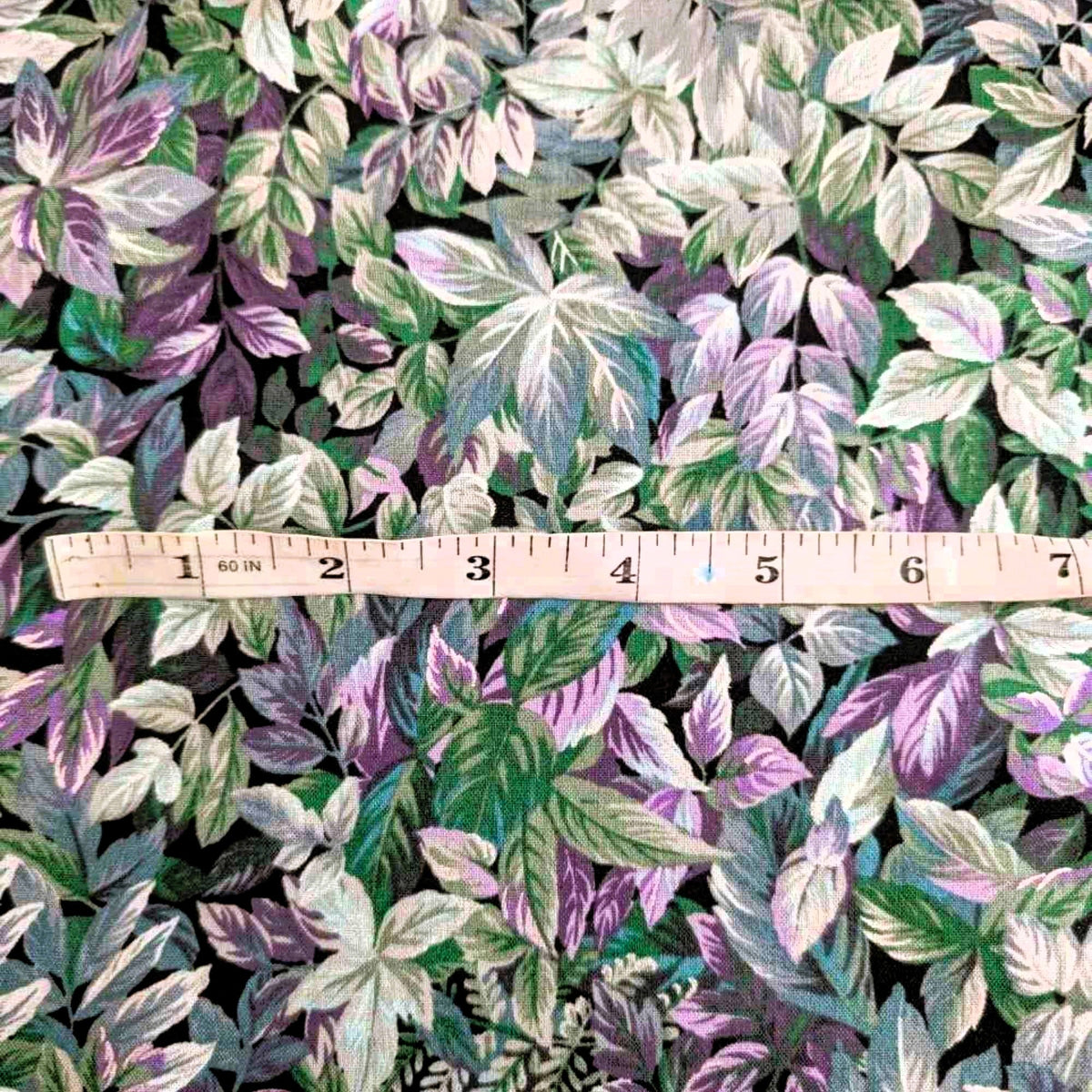 Heather in the Moonlight cotton fabric by Robert Kaufman with layered botanical leaf print in purple, green, blue, and metallic accents