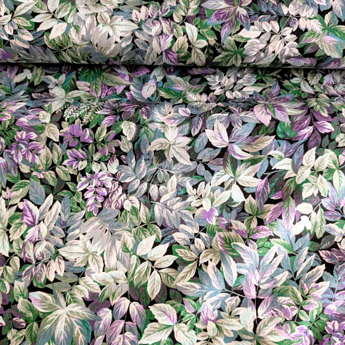 Heather in the Moonlight cotton fabric by Robert Kaufman with layered botanical leaf print in purple, green, blue, and metallic accents