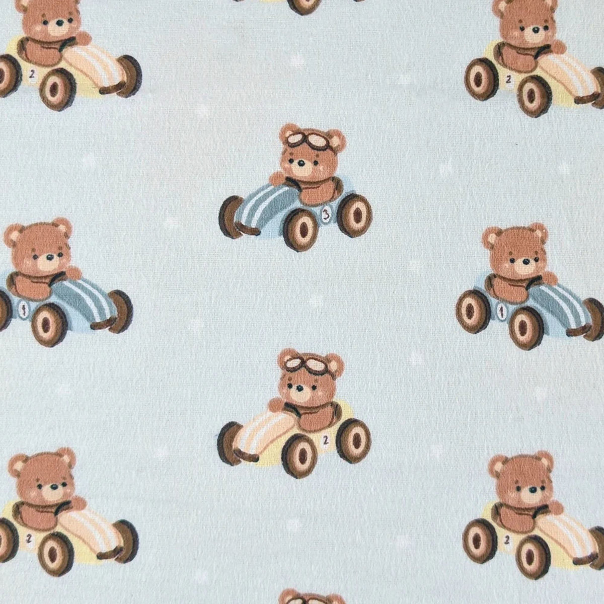 Camelot Fabrics Racing Teddies light blue cotton flannel fabric featuring teddy bears driving vintage toy race cars from the Fleece and Flannel 2026 Collection.