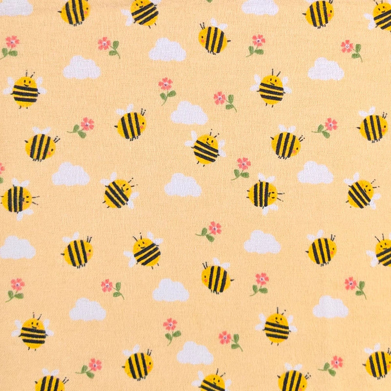 Camelot Fabrics Bumble Bees peach cotton flannel fabric featuring cheerful yellow bees, fluffy clouds, and pink flowers from the Fleece and Flannel 2026 Collection.