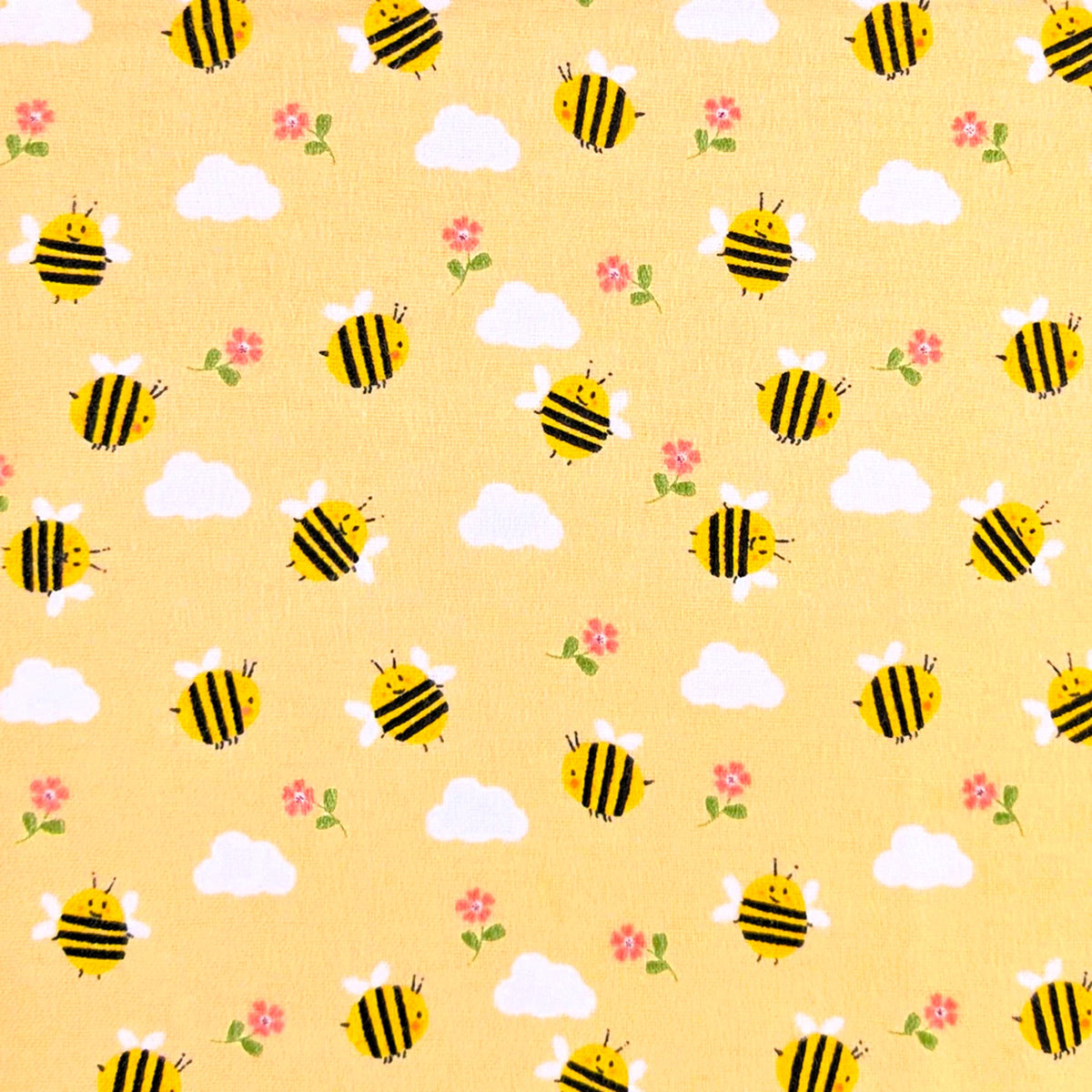 Camelot Fabrics Bumble Bees peach cotton flannel fabric featuring cheerful yellow bees, fluffy clouds, and pink flowers from the Fleece and Flannel 2026 Collection.