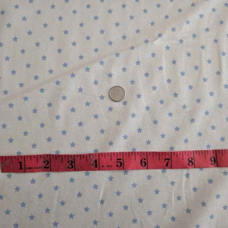 Organic cotton jersey knit fabric with blue star pattern on white background