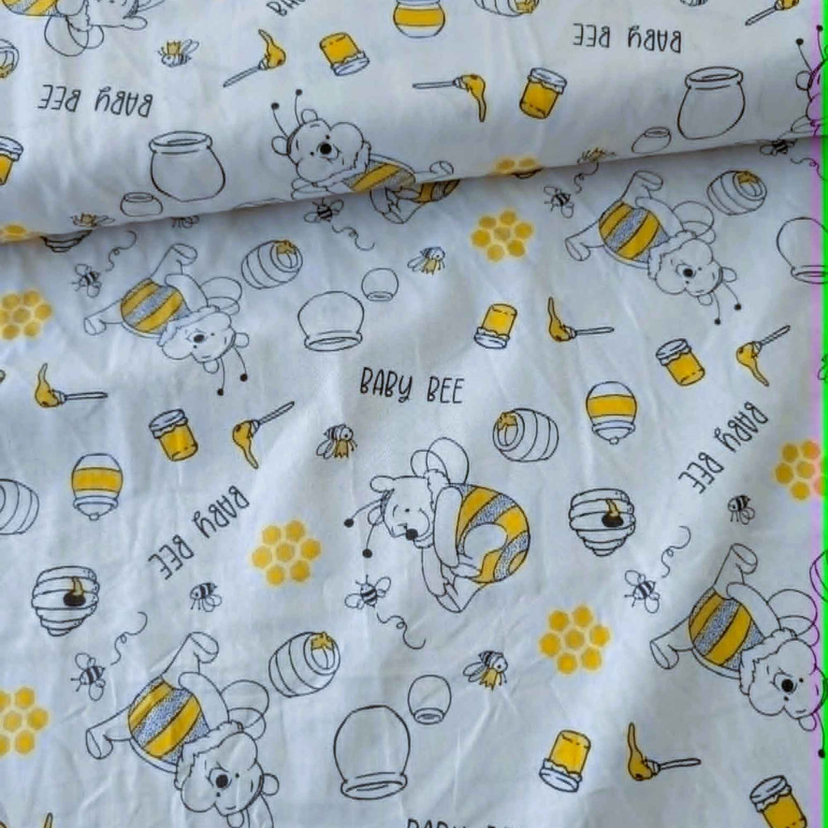 Disney Winnie the Pooh Busy Bee licensed cotton fabric by Springs Creative featuring Pooh dressed as a bee with honey pots, bees, honeycombs and beehives on a white background.