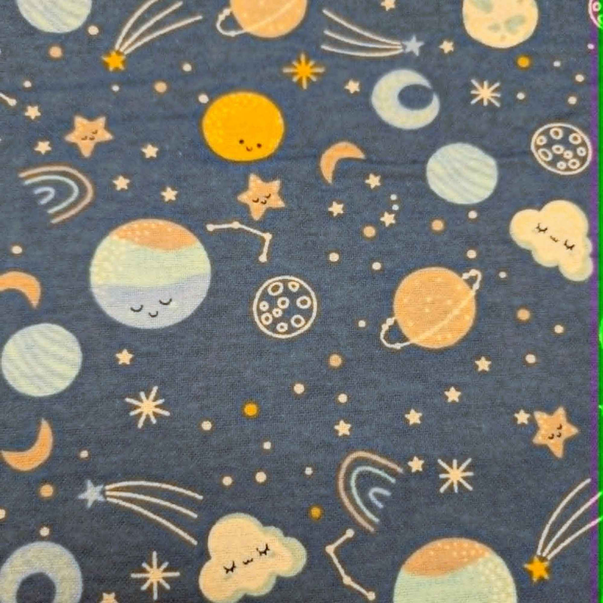 Camelot Fabrics Space Friends navy cotton flannel fabric featuring pastel planets, stars, moons, constellations, and shooting stars from the Fleece and Flannel 2026 Collection.