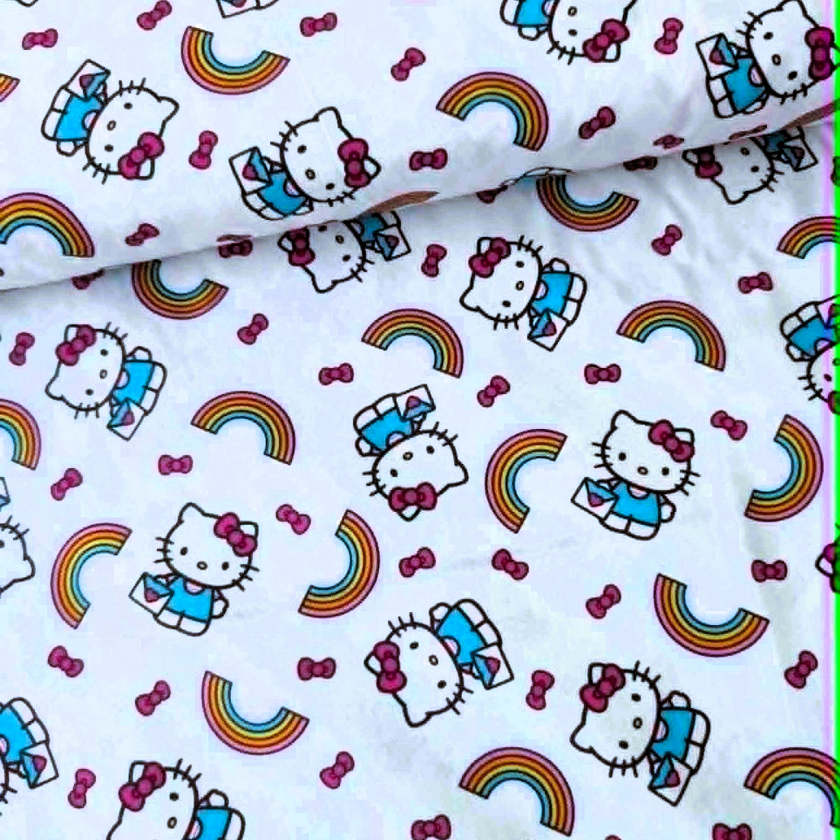 Officially licensed Hello Kitty rainbow cotton fabric by Springs Creative featuring Hello Kitty, colorful rainbows and pink bows on a white background.