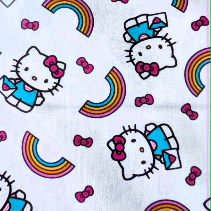 Officially licensed Hello Kitty rainbow cotton fabric by Springs Creative featuring Hello Kitty, colorful rainbows and pink bows on a white background.