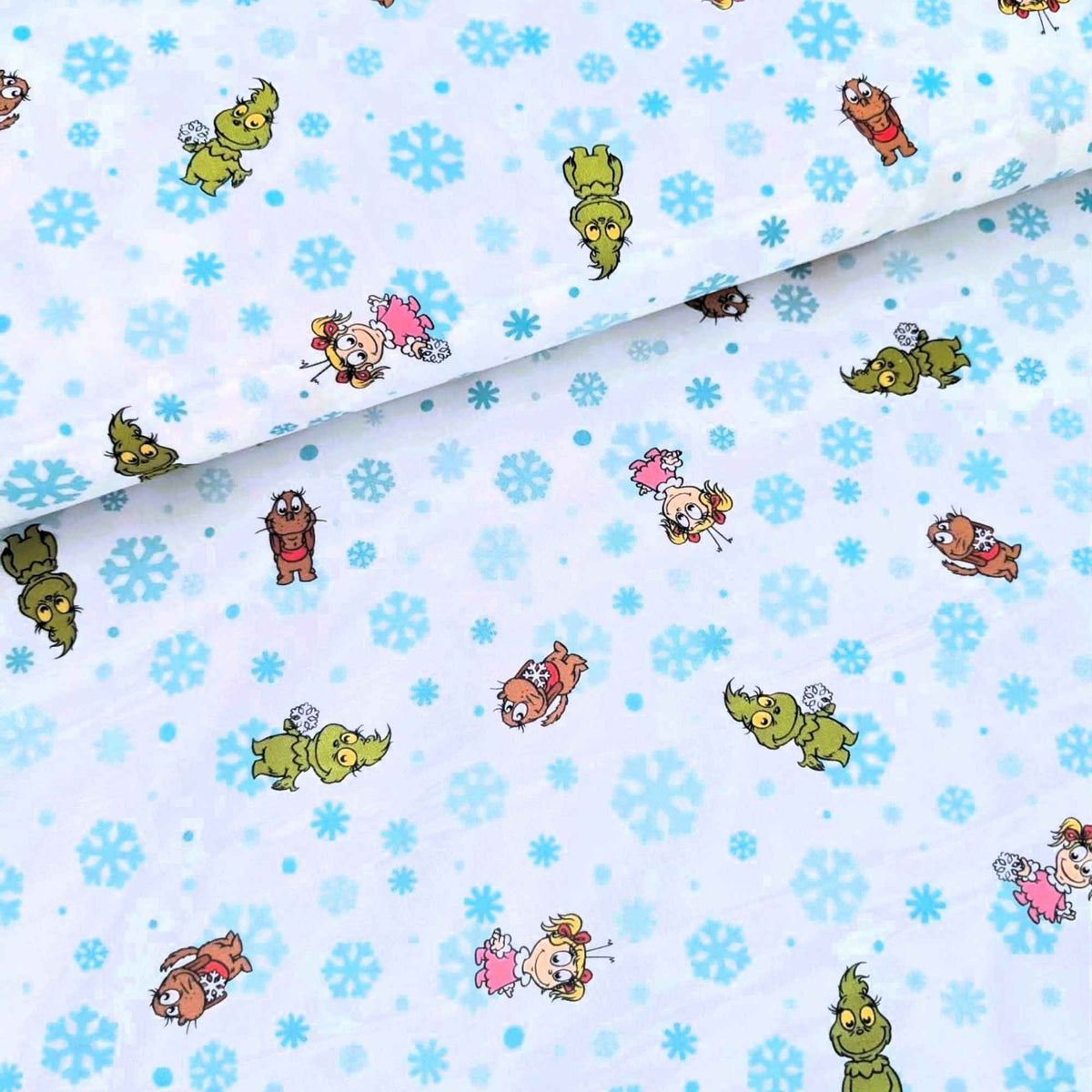 Little Grinch cotton fabric with Grinch characters and aqua snowflakes on white