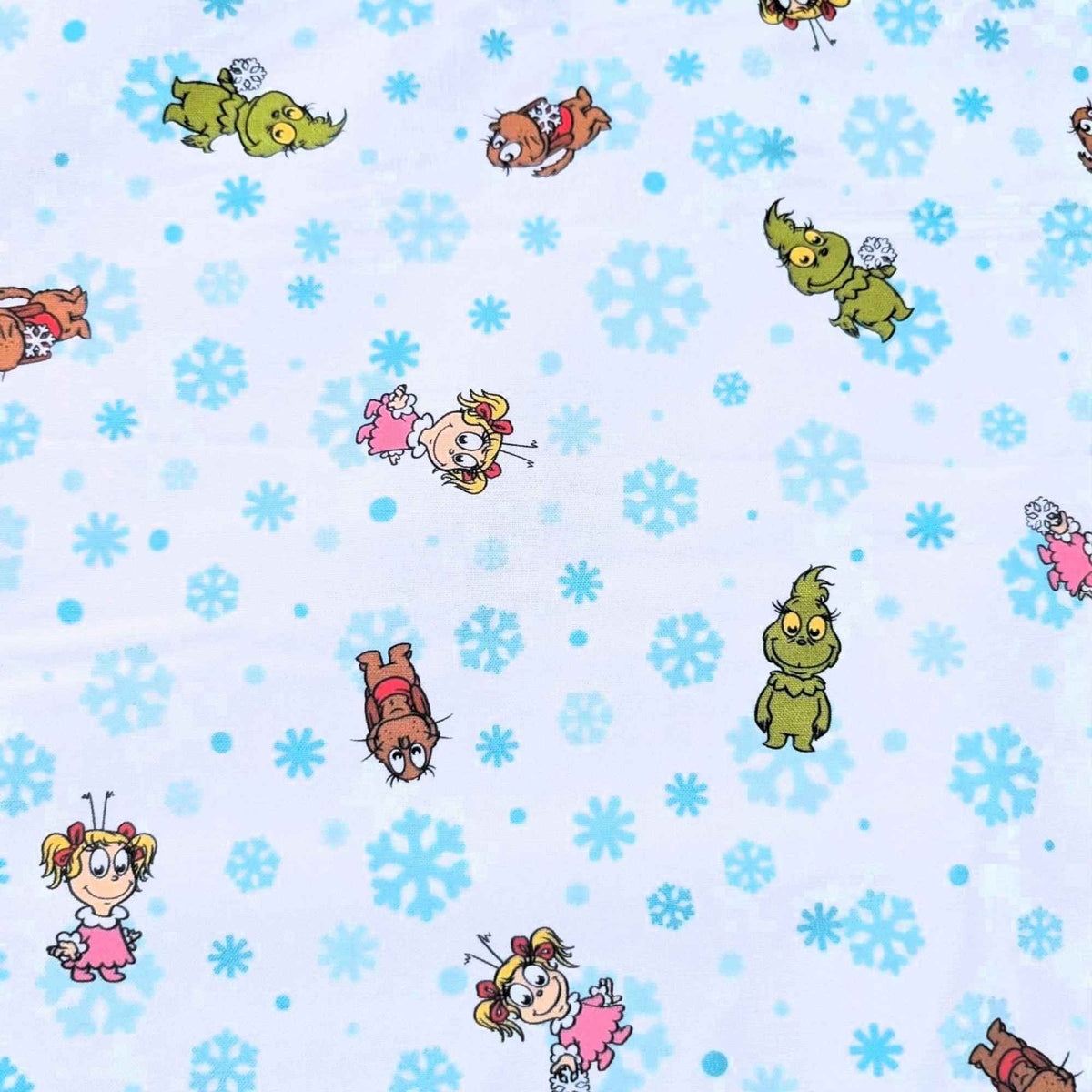 Little Grinch cotton fabric with Grinch characters and aqua snowflakes on white
