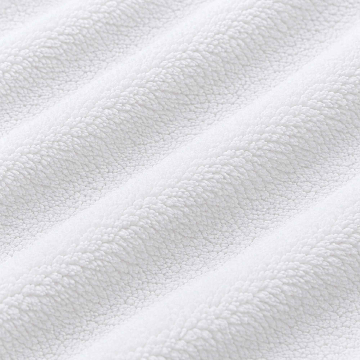 White anti-pill polar fleece fabric by Camelot Fabrics, showing soft, plush texture and smooth layered folds on a white background.