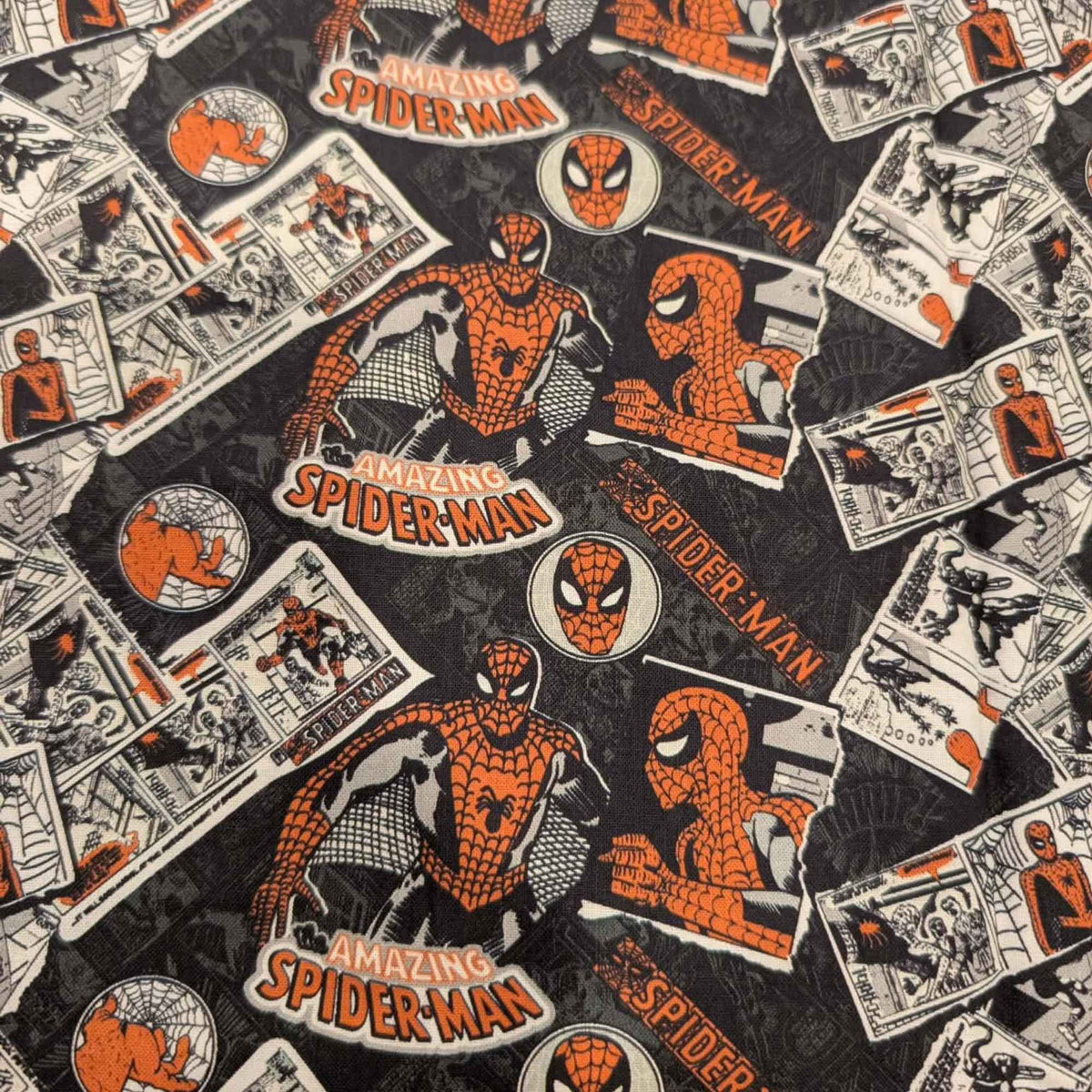 Marvel Amazing Spider-Man comic collage quilting cotton fabric featuring vintage comic panels, Spider-Man logos, character artwork, and mask icons on a black background.