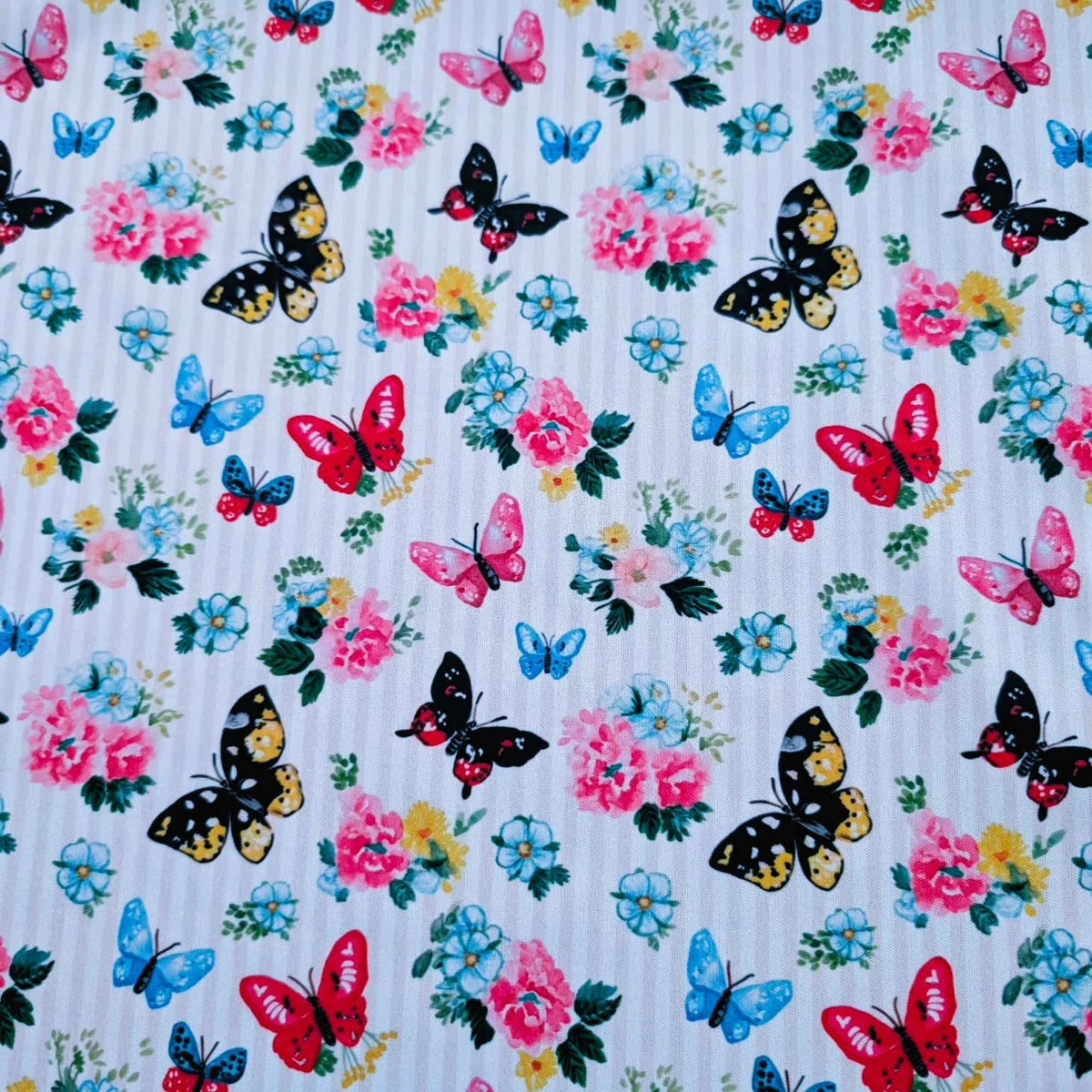 Colourful Butterfly Garden exclusive waterproof PUL fabric with blue, pink, red and yellow butterflies and flowers on yellow stripes