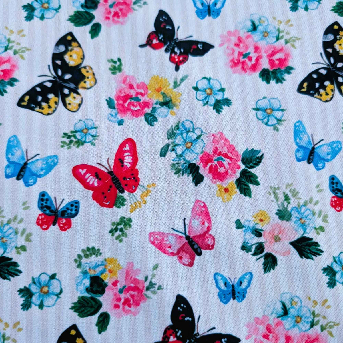 Colourful Butterfly Garden exclusive waterproof PUL fabric with blue, pink, red and yellow butterflies and flowers on yellow stripes