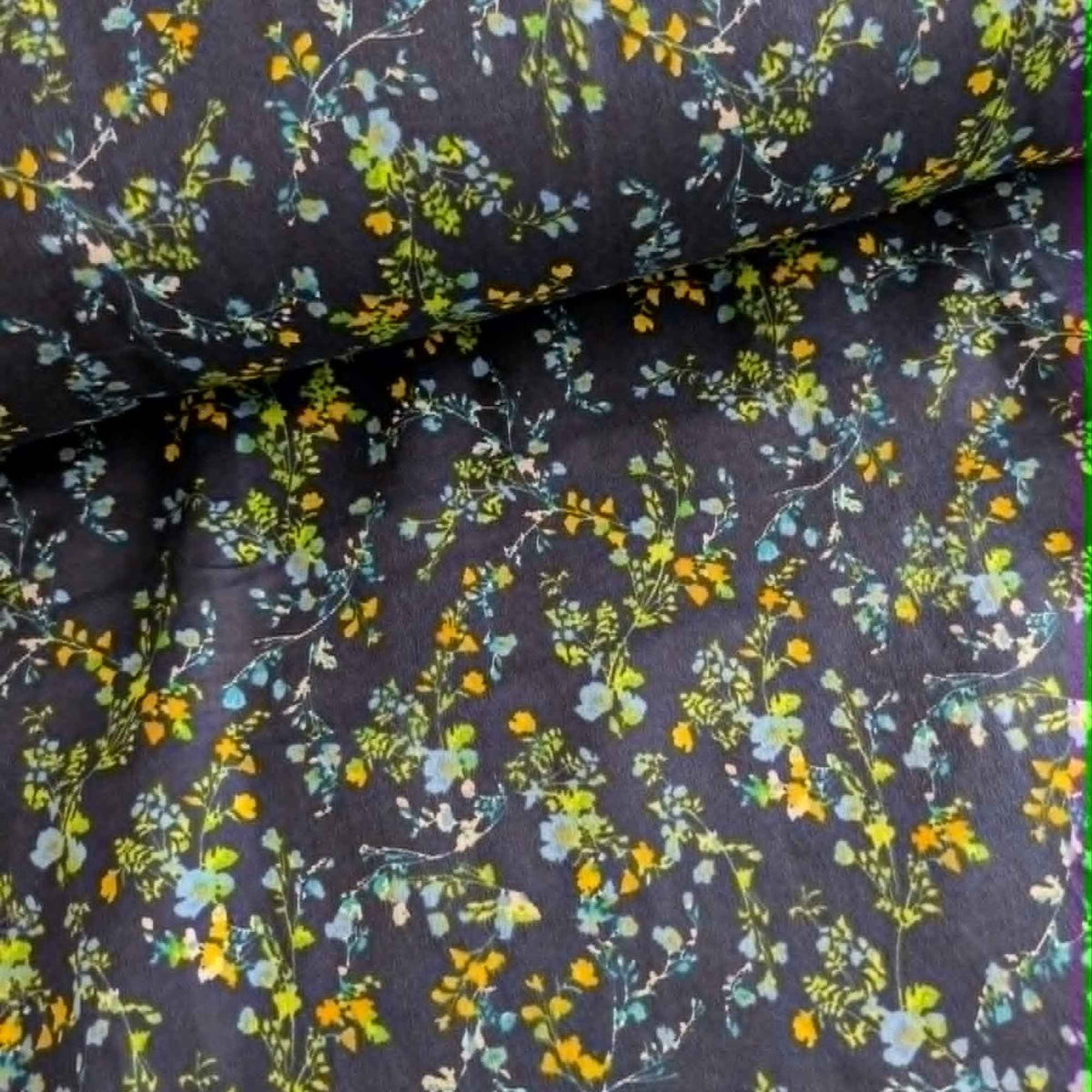 Double brushed flannel fabric featuring delicate yellow, blue, and green wildflowers with trailing vines on a navy background.