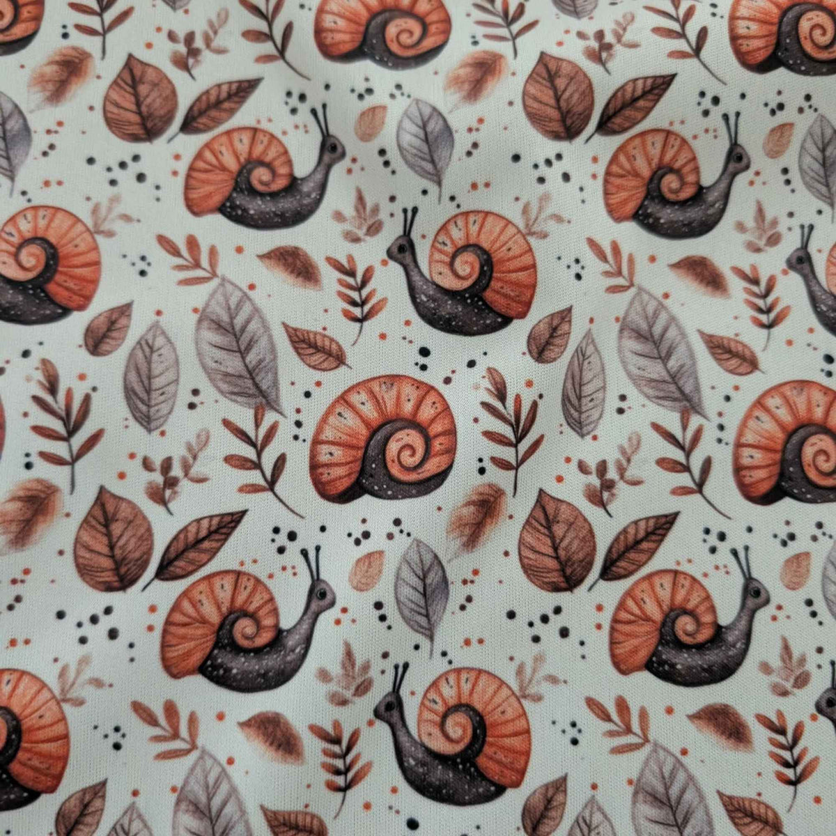 Woodland Snails and Autumn Leaves exclusive waterproof PUL fabric with orange-shelled snails and brown leaves on cream