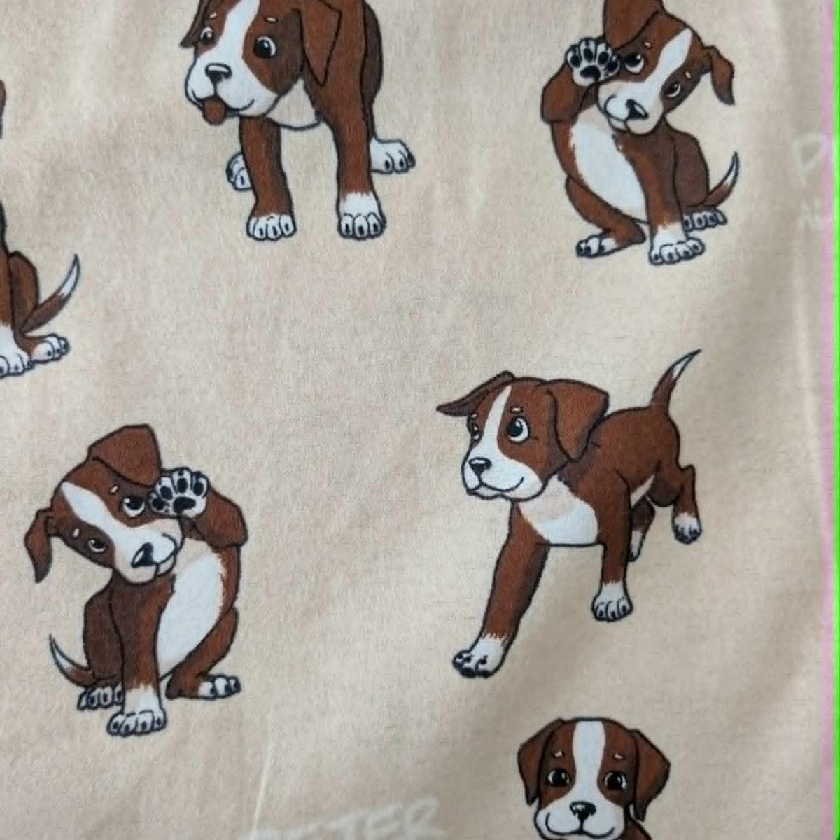 Double brushed flannel fabric featuring playful brown and white puppies in various poses on a cream background.