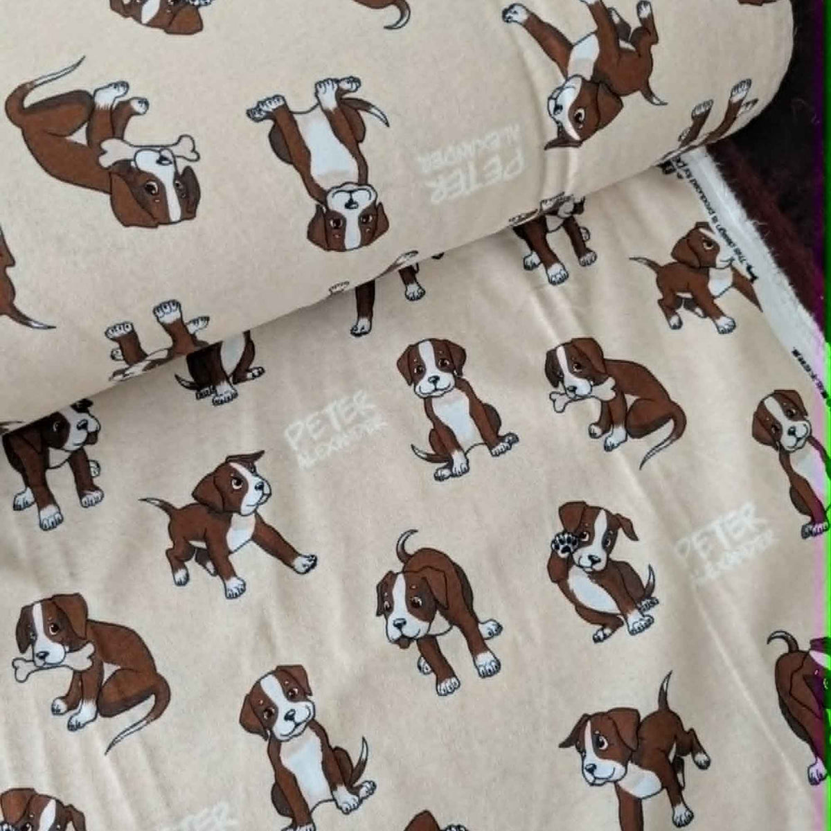 Double brushed flannel fabric featuring playful brown and white puppies in various poses on a cream background.