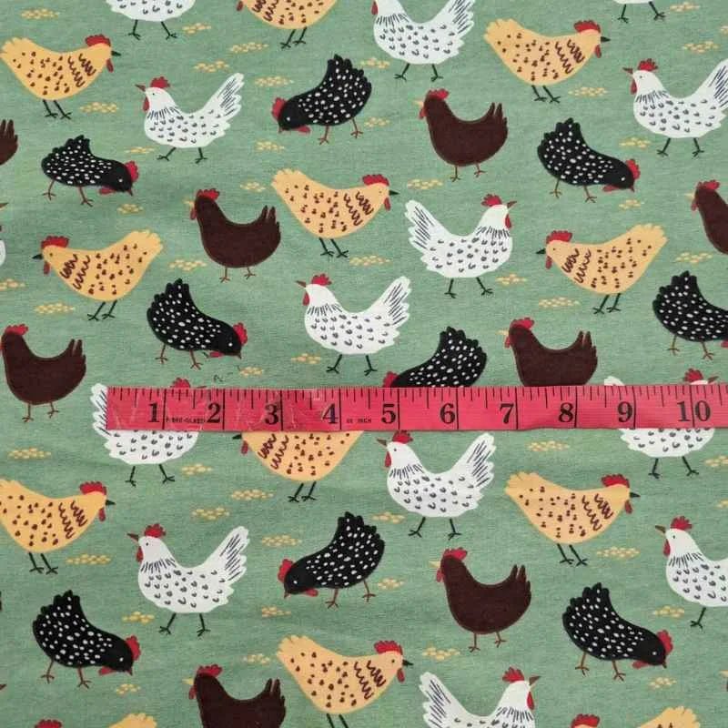 Cotton flannel fabric with beige, black, and white chickens scattered on a soft green background – ideal for quilts, blankets, and farmhouse-themed projects.