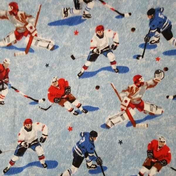 Light blue fabric featuring a repeating pattern of ice hockey players in red, white, and blue skates with black shadows and small star accents.