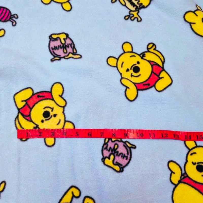 Winnie the Pooh anti-pill fleece on light blue with honey jars. Soft, cozy fabric for blankets, scarves, and crafts.