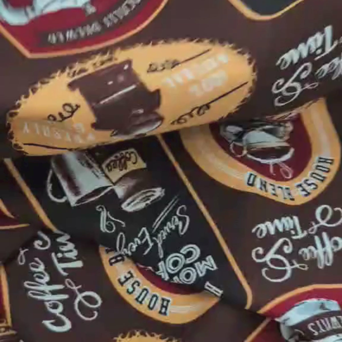 Video of Cotton fabric with retro-style coffee labels, mugs, and grinders on a brown background – 44” wide